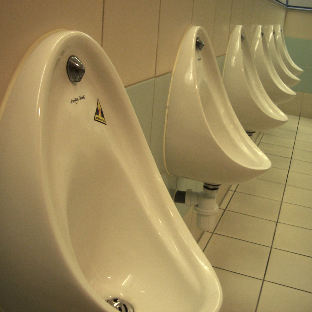 An 'Antisocial' warning sticker, reading: inter-urinal splashback